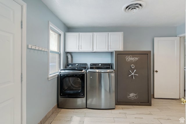 laundry area featuring washing machine and clothes dryer, visible vents, wood finish floors, cabinet space, and baseboards
