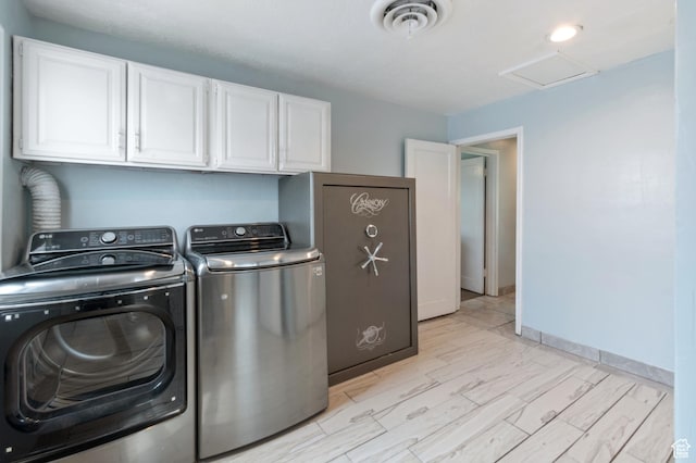 laundry area featuring visible vents, washer and dryer, attic access, wood finish floors, and cabinet space
