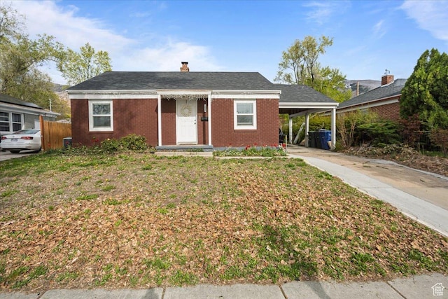 3048 S Harrison Blvd, Ogden, UT 84403 - view of front of house featuring driveway, fence, a carport, and a chimney