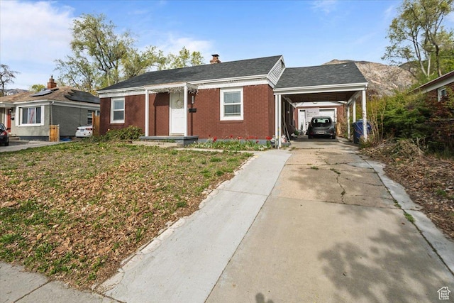 3048 S Harrison Blvd, Ogden, UT 84403 - view of front of property with a chimney, concrete driveway, an attached carport, and brick siding