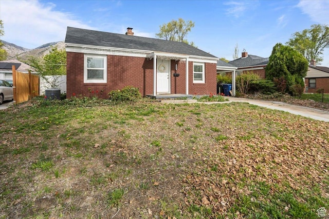 3048 S Harrison Blvd, Ogden, UT 84403 - bungalow-style house featuring an attached carport, a mountain view, brick siding, concrete driveway, and fence