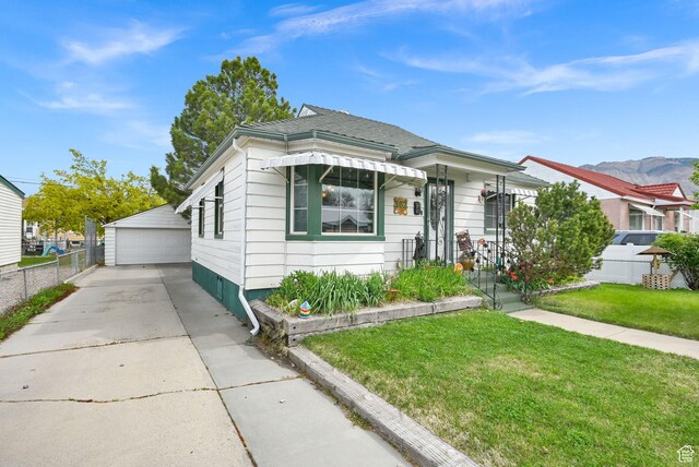 162 Mond St, Ogden, UT 84404 - view of front of home with a detached garage, a front lawn, an outbuilding, and fence