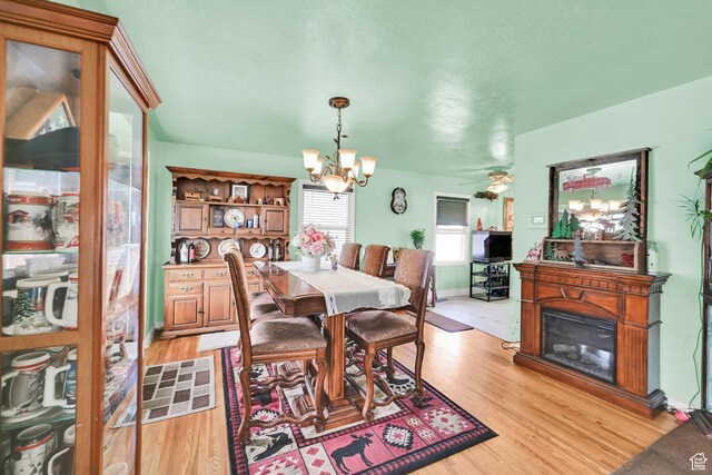 162 Mond St, Ogden, UT 84404 - dining space with a glass covered fireplace, a chandelier, light wood-type flooring, and baseboards