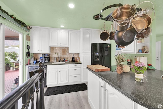 162 Mond St, Ogden, UT 84404 - kitchen with a sink, black refrigerator with ice dispenser, dark countertops, white cabinets, and wood finished floors