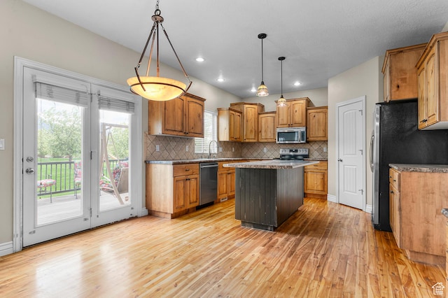 2254 N 1560 W, Pleasant Grove, UT 84062 - kitchen with brown cabinetry, tasteful backsplash, light wood-style flooring, a kitchen island, and appliances with stainless steel finishes