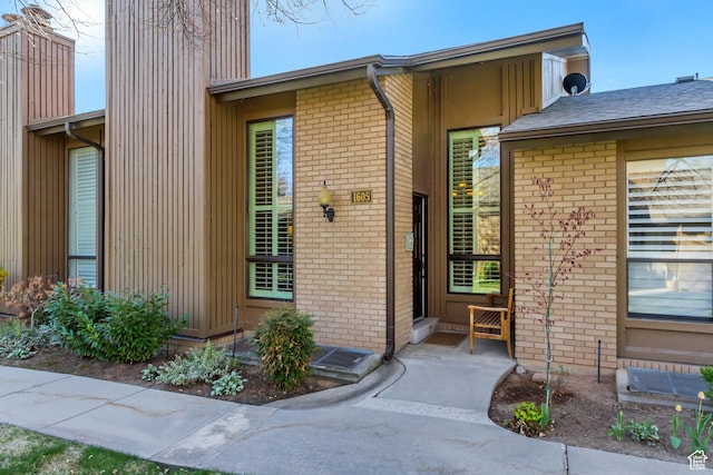 doorway to property with brick siding