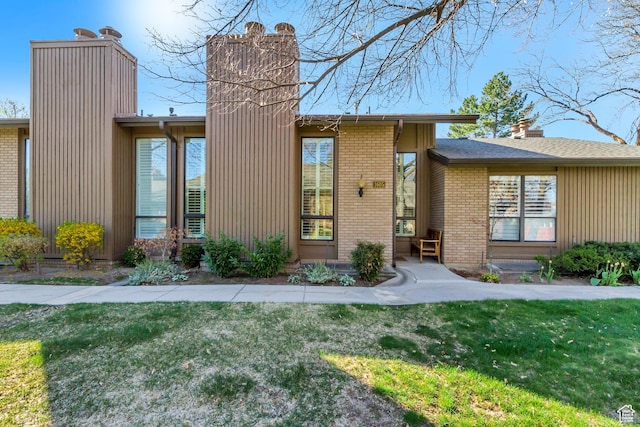 1605 E 6535 S, Murray, UT 84121 - mid-century home featuring a chimney, brick siding, and a front lawn