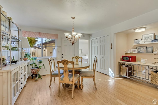 1605 E 6535 S, Murray, UT 84121 - dining space featuring a chandelier, light wood-style floors, and baseboards
