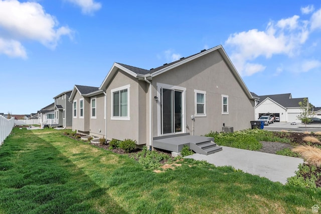 2982 S Craner Peak Dr, Magna, UT 84044 - back of house featuring stucco siding, a lawn, and a residential view