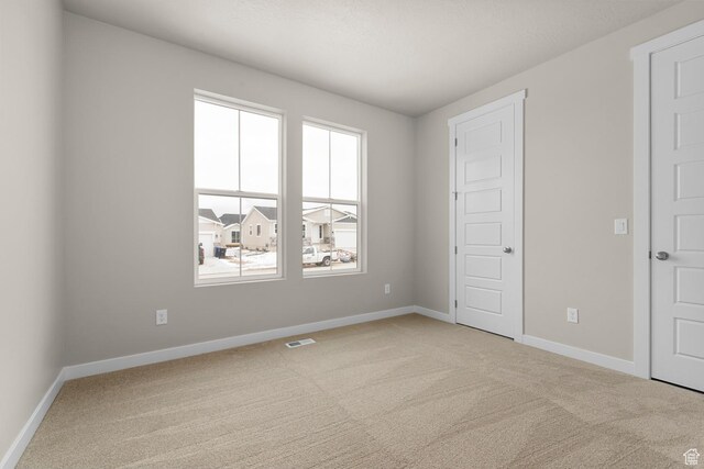 2982 S Craner Peak Dr, Magna, UT 84044 - unfurnished bedroom with baseboards, visible vents, and light colored carpet