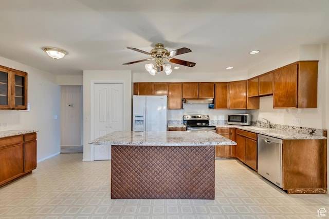 6796 S Nye Dr, Cottonwood Heights, UT 84121 - kitchen with under cabinet range hood, appliances with stainless steel finishes, brown cabinets, baseboards, and a ceiling fan