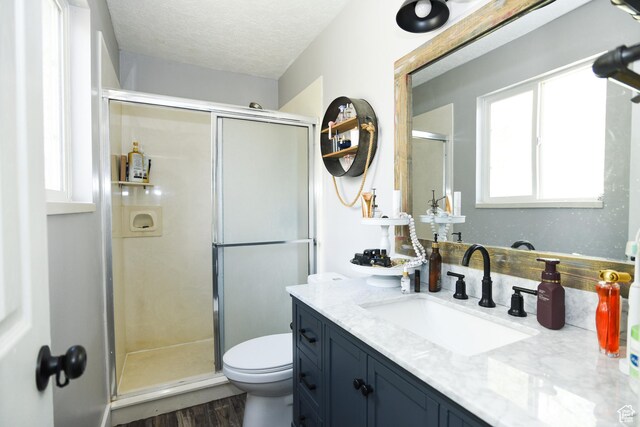 26 Orchard Ln S, Grantsville, UT 84029 - bathroom with vanity, toilet, a textured ceiling, a shower stall, and wood finished floors
