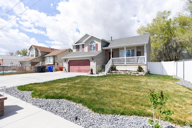 26 Orchard Ln S, Grantsville, UT 84029 - split level home featuring fence, an attached garage, a front yard, concrete driveway, and covered porch