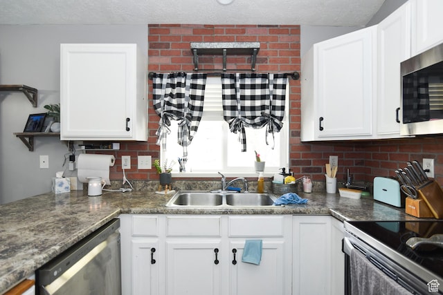 26 Orchard Ln S, Grantsville, UT 84029 - kitchen featuring appliances with stainless steel finishes, a sink, a textured ceiling, white cabinetry, and backsplash