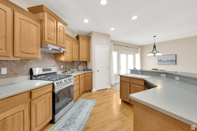 6872 S Triumph Ln, West Jordan, UT 84088 - kitchen with stainless steel range with gas stovetop, under cabinet range hood, a sink, decorative backsplash, and light wood finished floors