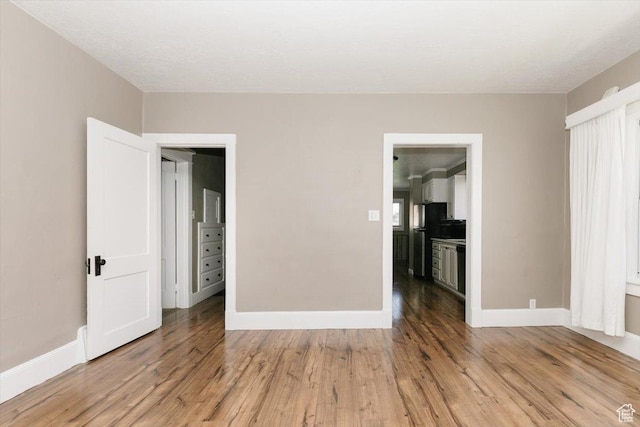 interior space featuring light wood-type flooring and baseboards
