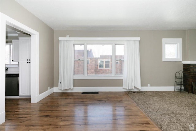 unfurnished living room featuring visible vents, baseboards, wood finished floors, and a fireplace