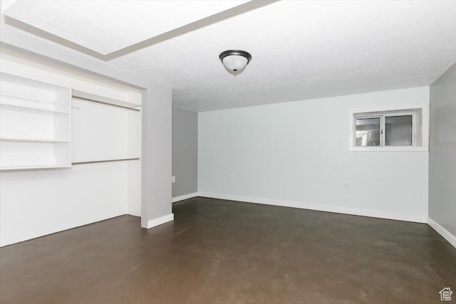 below grade area with baseboards and a textured ceiling