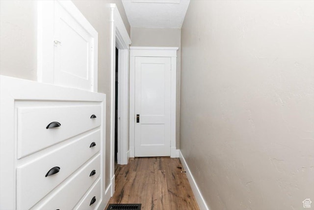 corridor with light wood-style floors and baseboards