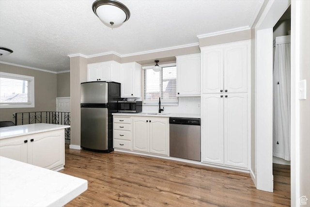 kitchen with plenty of natural light, a sink, white cabinetry, and appliances with stainless steel finishes