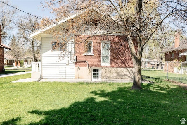 back of house with a lawn and fence