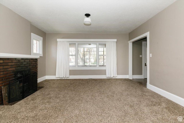 unfurnished living room with carpet floors, baseboards, and a brick fireplace