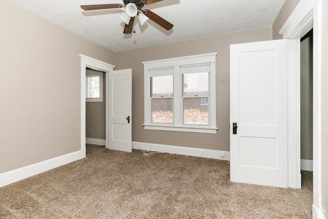 unfurnished bedroom featuring baseboards, ceiling fan, carpet, and a textured ceiling
