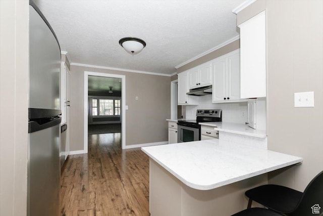 kitchen featuring white cabinets, stainless steel appliances, a peninsula, wood finished floors, and under cabinet range hood