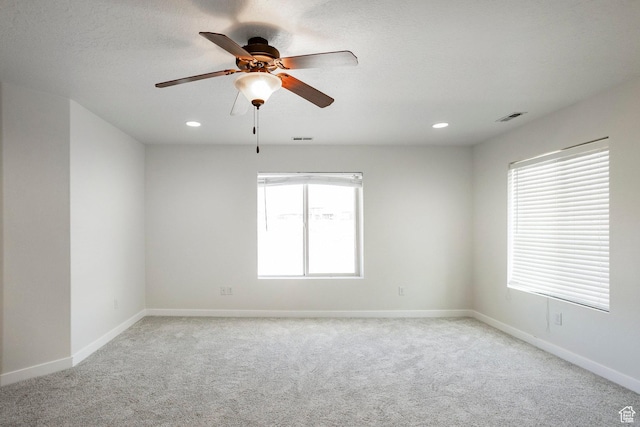 unfurnished room featuring visible vents, baseboards, a ceiling fan, and light carpet
