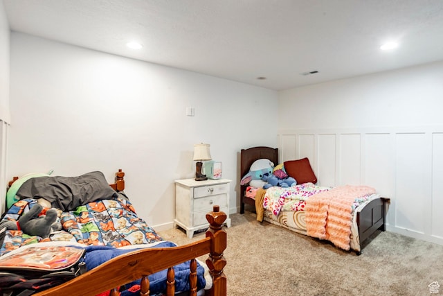 carpeted bedroom with visible vents, wainscoting, and recessed lighting