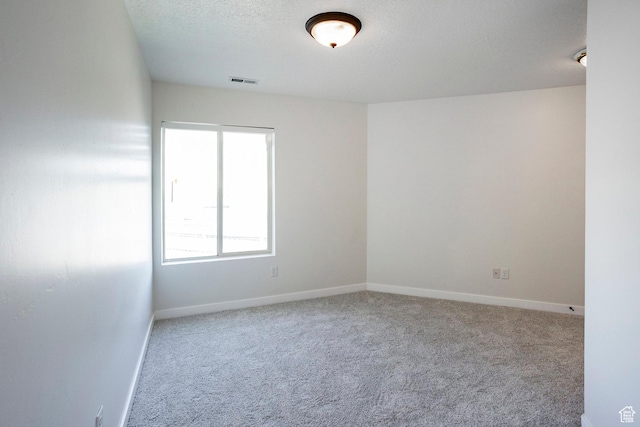 empty room with visible vents, carpet flooring, and baseboards