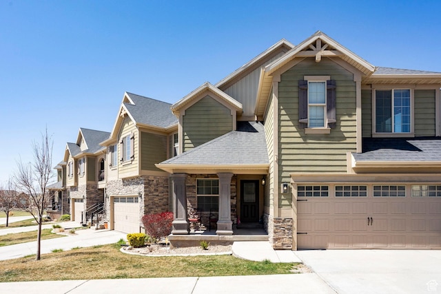 craftsman inspired home featuring driveway, covered porch, stone siding, and a garage