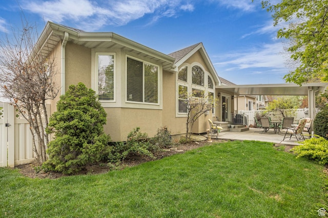 rear view of property featuring stucco siding and a patio