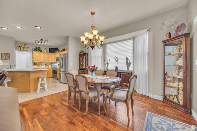 dining room featuring a chandelier, recessed lighting, light wood finished floors, and baseboards