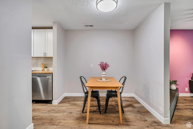 2270 E 4500 S Unit 2A, Holladay, UT 84117 - dining room with light wood-type flooring, a textured ceiling, and baseboards