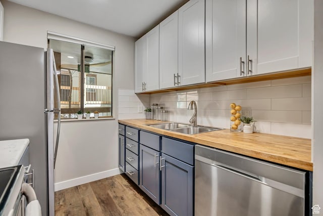 2270 E 4500 S Unit 2A, Holladay, UT 84117 - kitchen with stainless steel appliances, a sink, wood counters, wood finished floors, and decorative backsplash