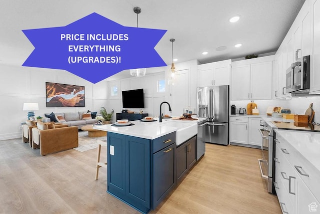 kitchen with a sink, stainless steel appliances, light wood-style flooring, light countertops, and white cabinets