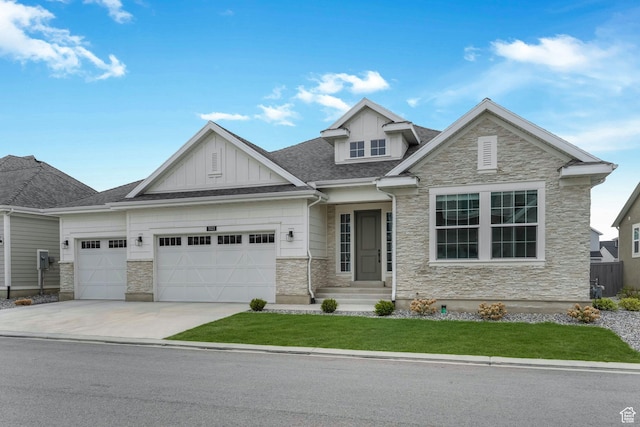 craftsman-style home with board and batten siding, concrete driveway, stone siding, a front lawn, and a garage