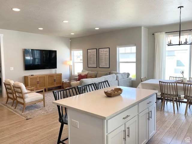 4190 W Penstemon Way, Lehi, UT 84043 - kitchen featuring recessed lighting, a kitchen bar, white cabinets, and light wood-style floors