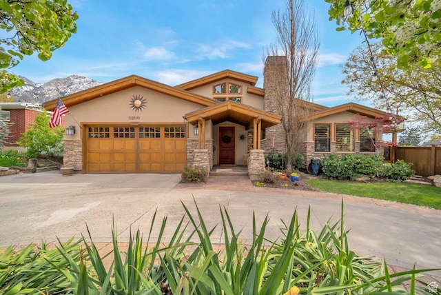 view of front of property with concrete driveway, stone siding, stucco siding, and a garage