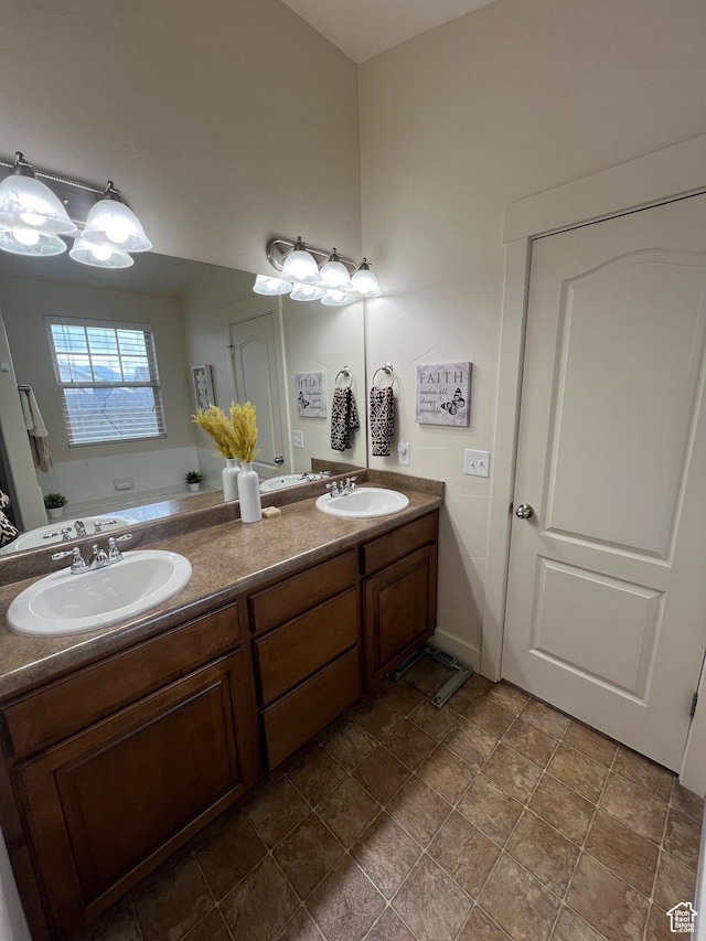 bathroom with double vanity, a sink, and stone finish flooring