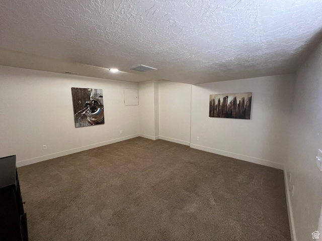 finished below grade area with dark carpet, a textured ceiling, and baseboards