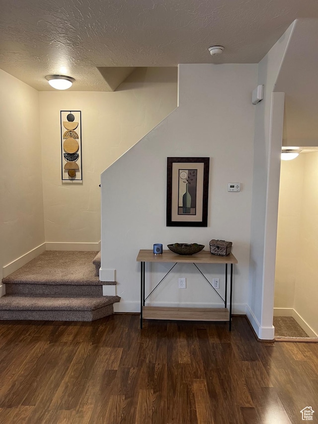 stairs featuring baseboards, a textured ceiling, and wood finished floors