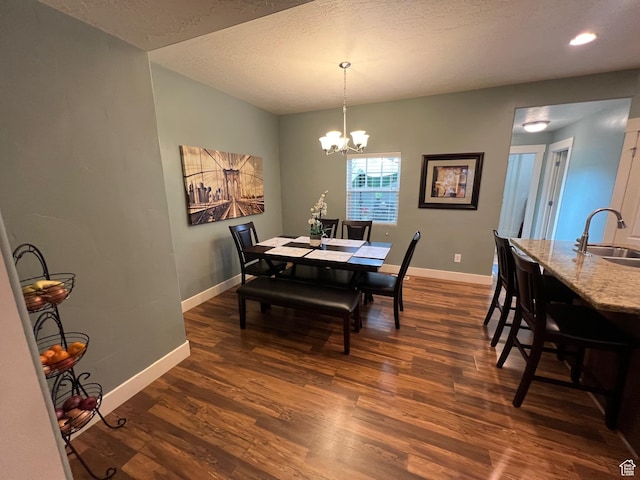 dining room with baseboards, a textured ceiling, a chandelier, and dark wood-style floors