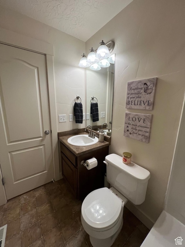 bathroom featuring vanity, a textured ceiling, and toilet