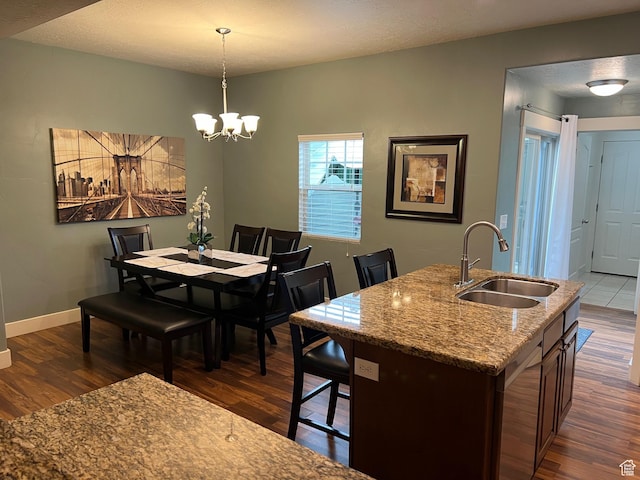 dining area featuring baseboards, a chandelier, and dark wood-style floors