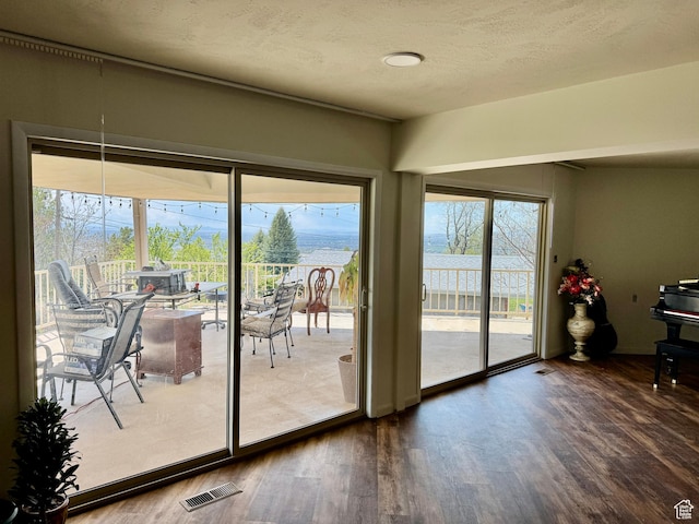 397 W 4125 N, Pleasant View, UT 84414 - doorway to outside featuring dark wood finished floors, a textured ceiling, and visible vents