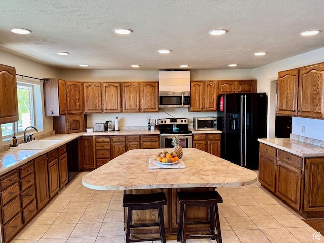 397 W 4125 N, Pleasant View, UT 84414 - kitchen featuring a sink, light countertops, brown cabinetry, and black appliances