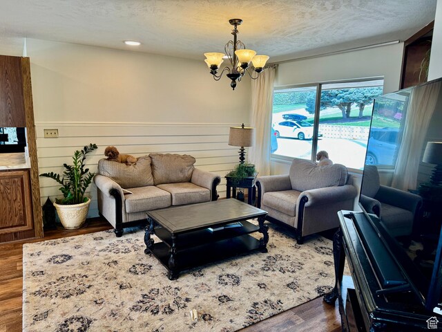 397 W 4125 N, Pleasant View, UT 84414 - living area with a wainscoted wall, a textured ceiling, wood finished floors, and a chandelier