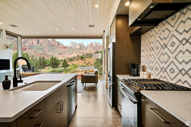 112 Canyon Cv, Springdale, UT 84767 - kitchen with range hood, a sink, concrete flooring, stainless steel appliances, and dark brown cabinetry
